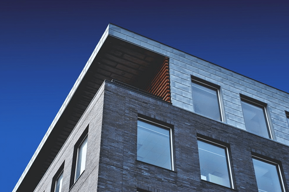 Modern passive house with large windows and solar panels on the roof.
